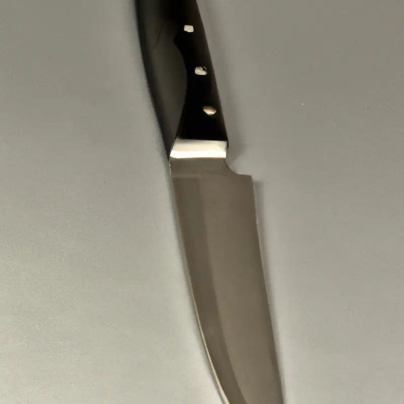 Sharp serrated knife slicing kiwi.